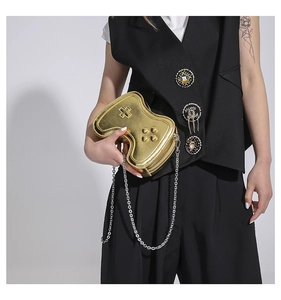Detail der kreativen Gamecontroller-Tasche in Goldoptik mit silberner Kette