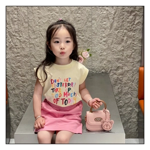 Toddler girl modeling yellow sleeveless t-shirt with pink skirt and mini handbag