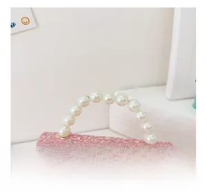 Detail of pink sequin girl's bag featuring pearl handle and My Melody cartoon charm