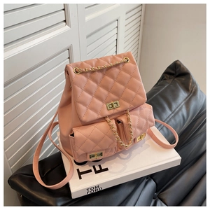 Detailed view of pink quilted leather backpack with gold twist locks and metal chain accents