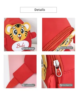 Detailansicht von Metallreißverschluss und Tiger-Stickerei auf roter Kinder-Brusttasche