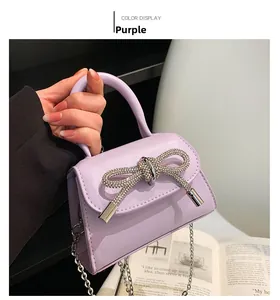 Close-up of purple mini chain bag with an oversized sparkling rhinestone bow detail