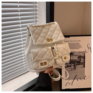 Close-up of white quilted leather backpack with gold chain straps and twist-lock pockets