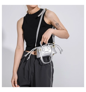 Silver metallic mini crossbody bag with drawstring closure and top handles on model