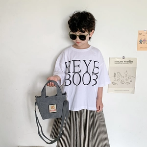 Grey corduroy kids tote bag with cute bear patch and crossbody strap in a minimalist setting