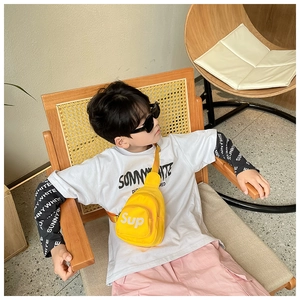 Détail d'un sac de poitrine en toile jaune vif avec lettrage sur un t-shirt enfant