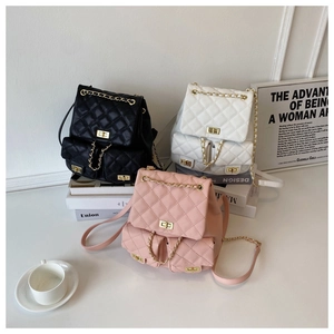 Close-up of quilted mini backpacks in black, white and pink with gold chain hardware