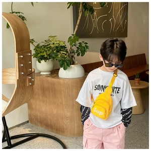 Gros plan sur un sac de poitrine jaune en toile pour enfants avec sangle réglable