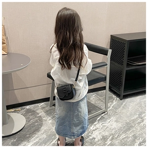 Rear view of child wearing black lychee pattern crossbody bag with chic outfit