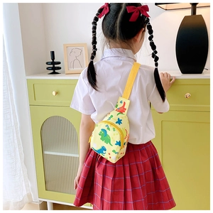 Kids yellow chest bag with colorful dinosaur prints worn by child in a cozy home setting