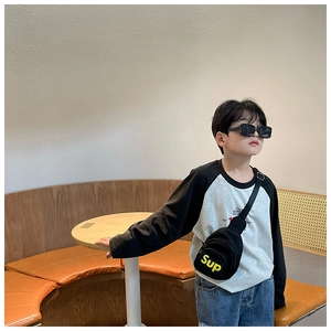 Détail d'un sac de poitrine noir en toile pour enfant avec broderie jaune Sup