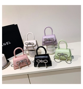 Detail of mini trapezoid handbags with rhinestone bows and silver chains in five colors