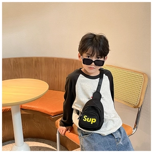 Détail d'un sac de poitrine noir pour enfant en toile avec lettres Sup jaunes
