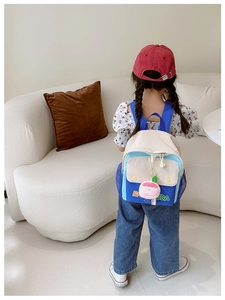 Close-up of color-block canvas kids backpack with embroidered letters and strawberry charm
