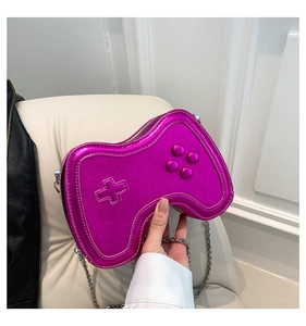 Detailaufnahme einer lila Umhängetasche in Gamepad-Form aus glänzendem Lackleder-Material