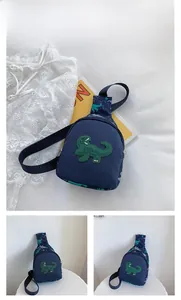 Détail du sac de poitrine en toile bleu foncé pour enfants avec patch dinosaure vert