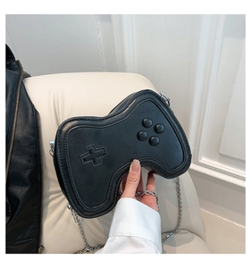 Detailaufnahme einer schwarzen Umhängetasche in Gamepad-Form mit Kette aus gestepptem PU