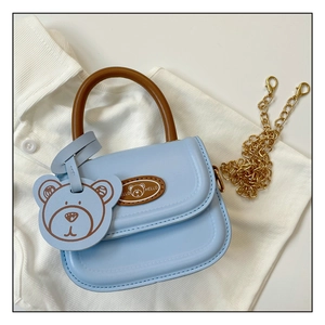 Detail of light blue mini bear purse with brown handle and detachable gold chain strap