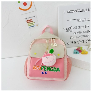 Detail of cute color-block canvas kids backpack with heart print and peach plush charm