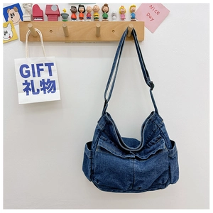Detail of dark blue denim crossbody bag with functional multi-pockets and adjustable strap