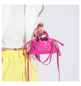 Detail of neon pink mini crossbody bag with drawstring liner and fashion text print