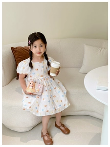 Girl's summer princess dress with colorful polka dots and puff sleeves in lifestyle setting