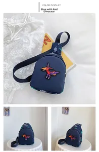 Détail de la broderie dinosaure et de la sangle sur le sac de poitrine bleu pour enfant