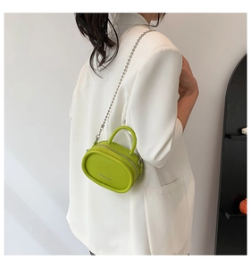 Detailed macro view of the bright green litchi texture on this mini chain crossbody bag