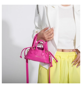 Close-up of a mini fuchsia tote bag with drawstring detail and golden hardware