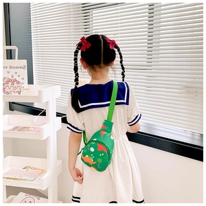 Close-up of a green dinosaur canvas sling bag for girls with cute cartoon print patterns