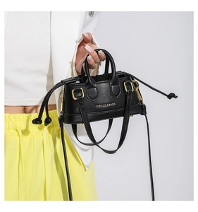 Detail of a black mini crossbody bag with gold hardware and Fashion & Bags text logo