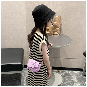 Girl's purple PU leather mini crossbody bag shown on child model in lifestyle setting