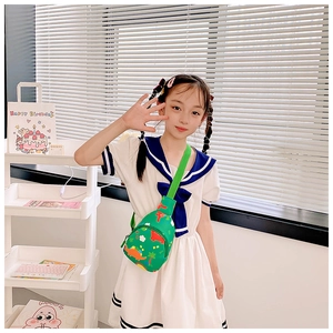 Close-up of children's dinosaur chest bag with colorful cartoon prints and green strap