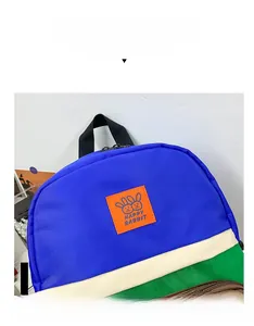 Detail of color-block canvas backpack featuring Happy Rabbit leather patch and nylon straps
