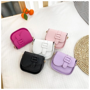 Flat lay of five mini PU leather saddle bags in bright colors with gold hardware detail