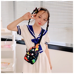 Close-up of children's black dinosaur chest bag with colorful patterns and adjustable strap