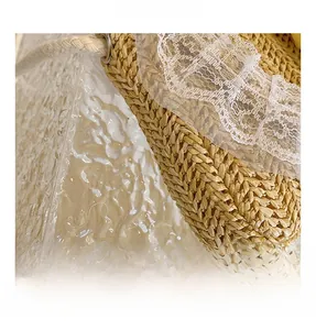 Macro shot of woven straw texture and white flower lace trim on a girl's mini summer bag