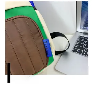 Detail of color-block canvas backpack with quilted texture and blue fashion side label