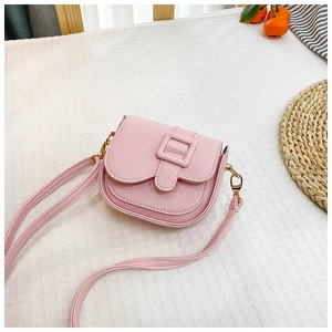 Macro detail of pink pebble leather mini saddle bag with golden metal hardware