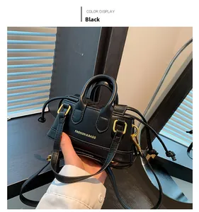 Detail of a mini black leather handbag with gold 'FASHION & BAGS' lettering and strap