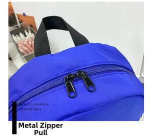 Detailed close-up of smooth metal zipper pulls and durable blue fabric on the backpack