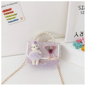 Detail of purple sequin girls handbag with pearl handle, lace trim and plush bunny doll