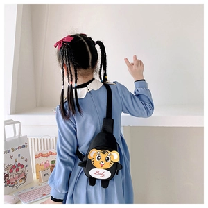 Rückansicht eines Kindes mit schwarzer Tiger-Brusttasche aus Canvas und Baby-Text