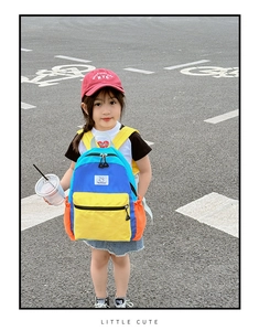 Détail du sac à dos enfant bicolore avec poche jaune zippée et filet latéral orange