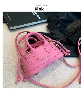 Pink mini crossbody bag featuring pebbled leather texture and elegant gold metal feet