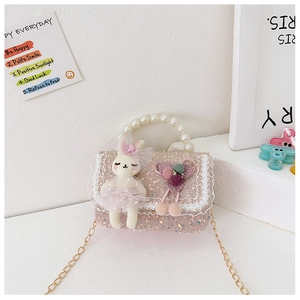 Detail of pink sequin girl's bag with pearl handle and cute bunny doll accessory