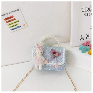 Detail of blue sequined kids handbag with bunny doll, pearl handle and lace trim