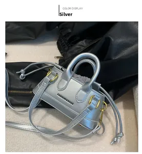 Detail view of mini silver Boston bag with metallic finish and gold hardware accents