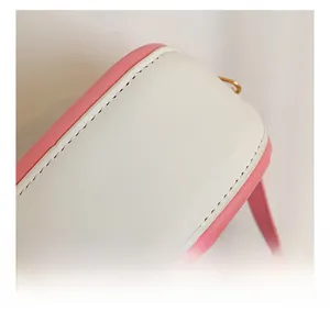 Détails des coutures et de la texture du sac en similicuir rose et blanc