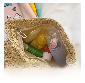 Detail view of woven straw bag interior showing storage space and metal zipper